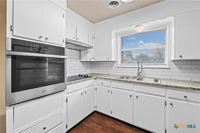 kitchen featuring white cabinetry, sink, dark hardwood / wood-style floors, a textured ceiling, and oven