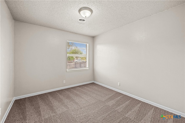 carpeted spare room featuring a textured ceiling