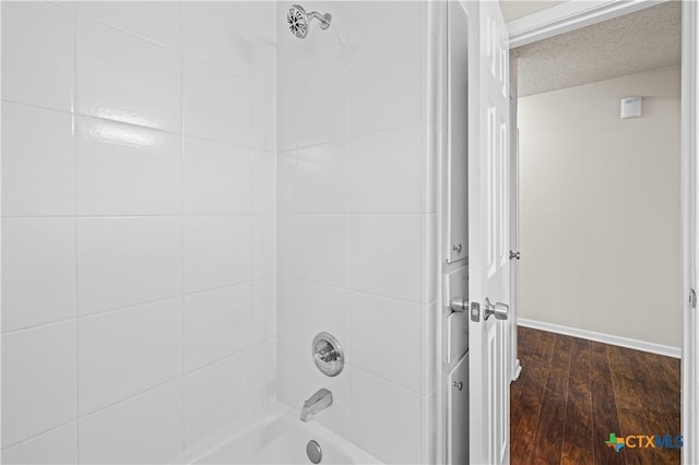 bathroom featuring tiled shower / bath, a textured ceiling, and wood-type flooring