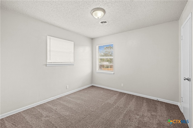 carpeted spare room with a textured ceiling