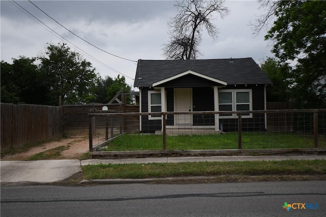 bungalow-style home with roof with shingles, a gate, covered porch, and a fenced front yard
