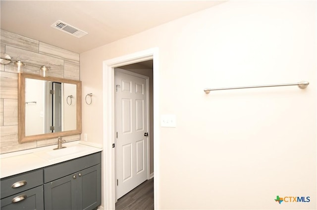 bathroom with visible vents, wood finished floors, and vanity