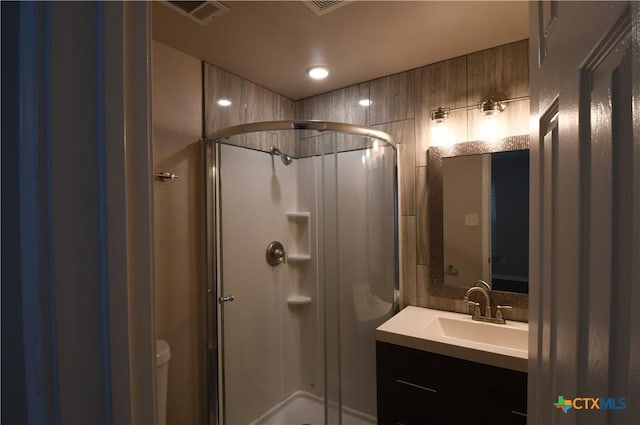 full bath featuring toilet, visible vents, a shower stall, and vanity