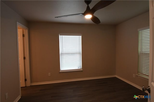 unfurnished room featuring baseboards, a ceiling fan, and dark wood-style flooring