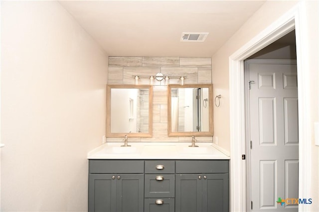 full bath with double vanity, visible vents, and a sink
