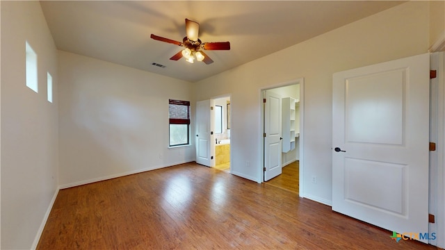 1802 Spring Valley Dr, Dripping Springs, TX 78620 - unfurnished bedroom featuring wood finished floors, ensuite bathroom, and a ceiling fan