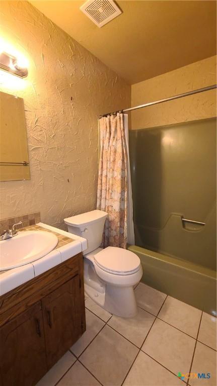 full bathroom with tile patterned flooring, vanity, toilet, and shower / bath combo