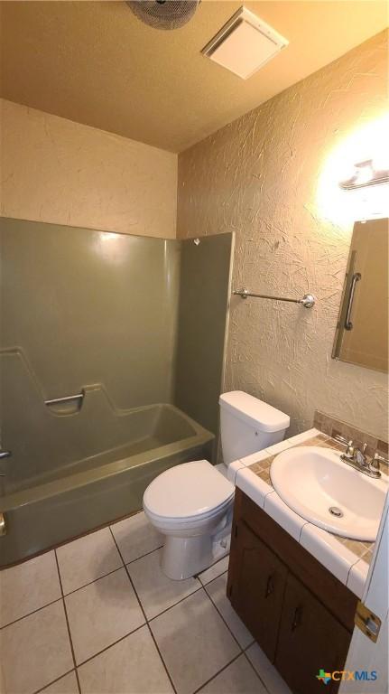 full bathroom with shower / tub combination, tile patterned flooring, vanity, and toilet