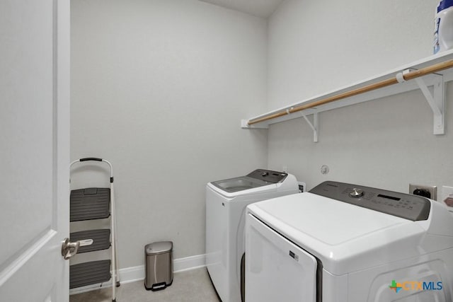 laundry room with laundry area, baseboards, light tile patterned floors, and washing machine and dryer
