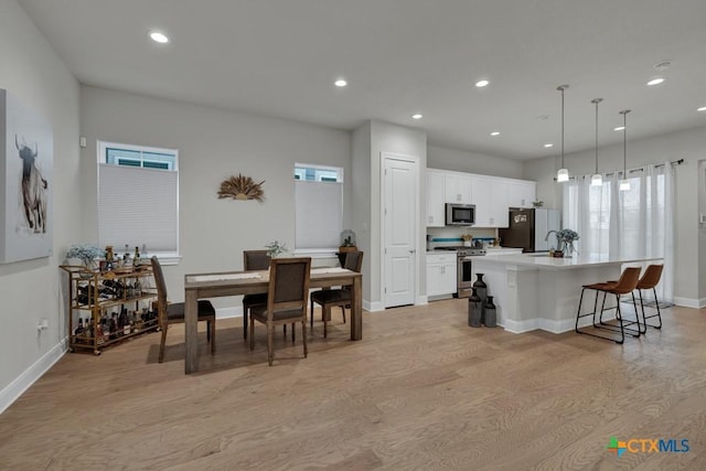 dining area with recessed lighting, baseboards, and light wood-style flooring