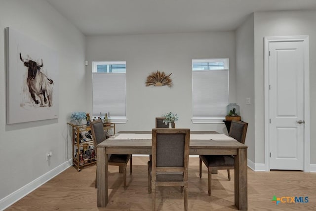 dining area featuring light wood-style floors and baseboards