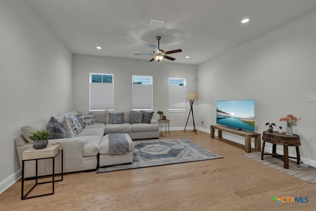 living area featuring a ceiling fan, visible vents, wood finished floors, baseboards, and recessed lighting