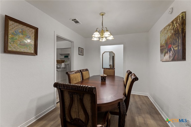 dining space with dark hardwood / wood-style flooring and a chandelier