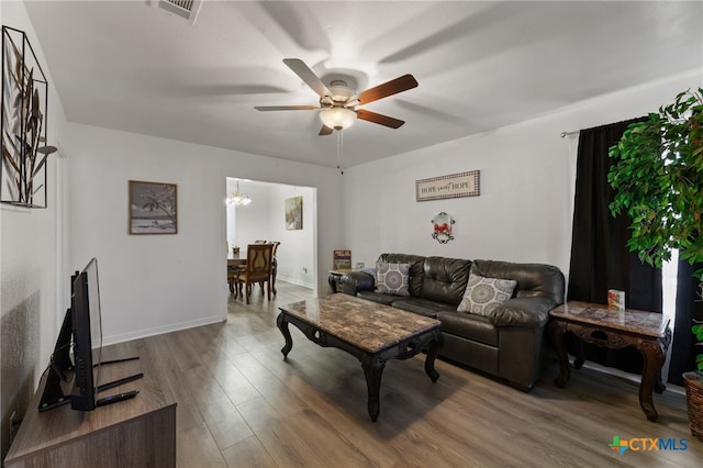 living room with wood-type flooring and ceiling fan with notable chandelier