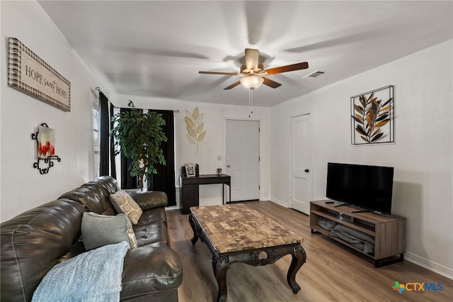 living room with light hardwood / wood-style flooring and ceiling fan