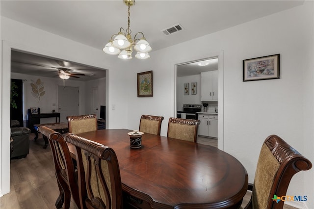 dining space with ceiling fan with notable chandelier and dark wood-type flooring