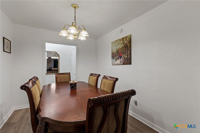 dining area with a notable chandelier and dark hardwood / wood-style floors