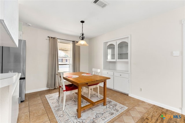 dining room featuring baseboards, visible vents, and light tile patterned flooring