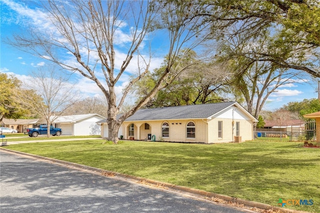 ranch-style house featuring fence, a front lawn, and brick siding