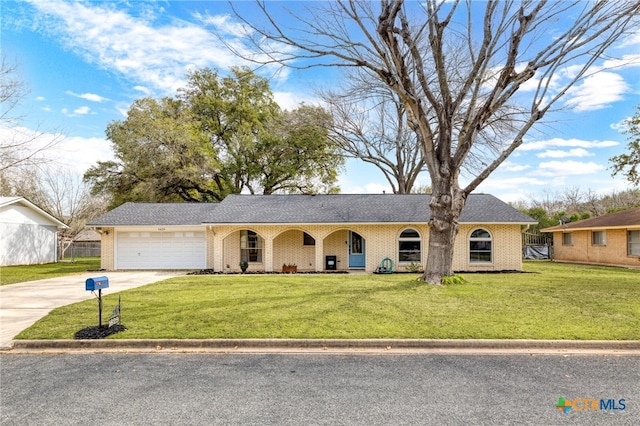 single story home featuring an attached garage, concrete driveway, brick siding, and a front yard