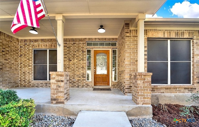 view of exterior entry with brick siding