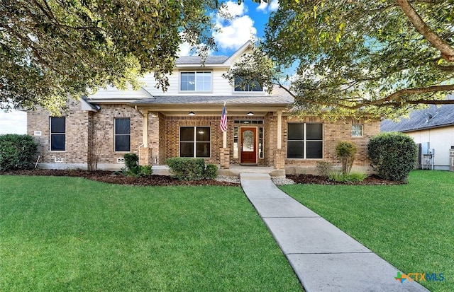 view of front facade featuring a front lawn, covered porch, and brick siding