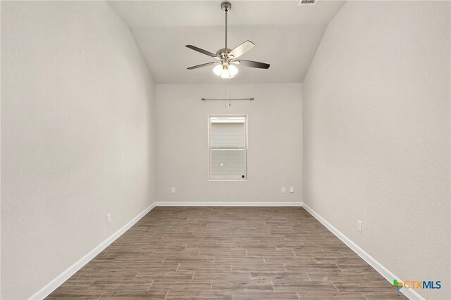 spare room featuring ceiling fan, lofted ceiling, and light wood-type flooring