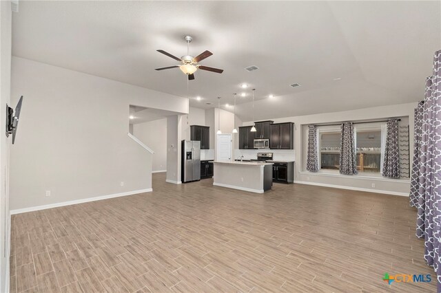 unfurnished living room featuring light hardwood / wood-style flooring, ceiling fan, and sink