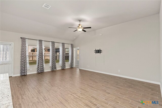 empty room with wood-type flooring, ceiling fan, and lofted ceiling