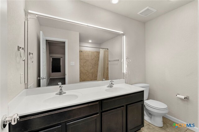 bathroom featuring tile patterned flooring, vanity, toilet, and curtained shower