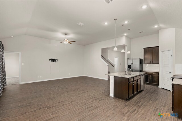 kitchen featuring pendant lighting, a center island with sink, sink, dark hardwood / wood-style flooring, and stainless steel fridge with ice dispenser