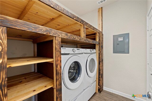 clothes washing area featuring wood ceiling, wood-type flooring, independent washer and dryer, and electric panel