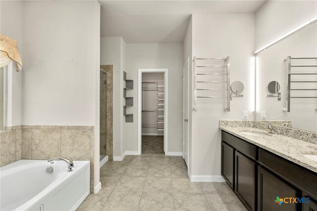 bathroom with tile patterned floors, separate shower and tub, and vanity