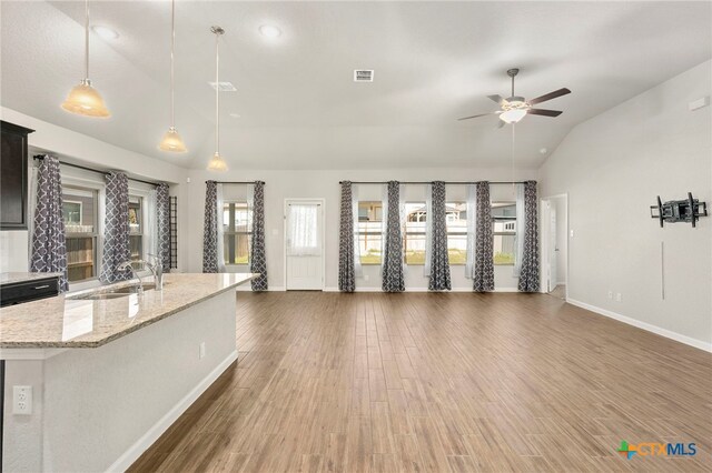 unfurnished living room with dark hardwood / wood-style flooring, vaulted ceiling, ceiling fan, and sink