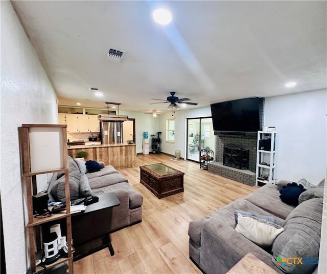 3043 Boys Ranch Rd, Kempner, TX 76539 - living area with light wood-style floors, a ceiling fan, a brick fireplace, and recessed lighting