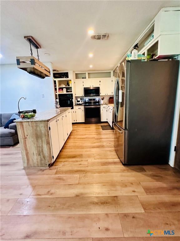 3043 Boys Ranch Rd, Kempner, TX 76539 - kitchen featuring appliances with stainless steel finishes, light wood finished floors, a peninsula, white cabinetry, and recessed lighting
