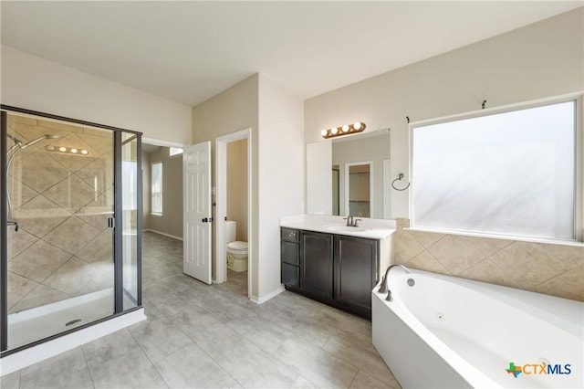 full bath featuring a garden tub, toilet, vanity, baseboards, and a stall shower