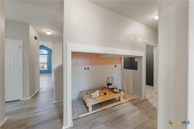 corridor featuring baseboards and wood finished floors