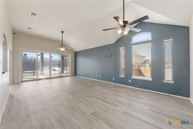 spare room with visible vents, a ceiling fan, wood finished floors, high vaulted ceiling, and baseboards