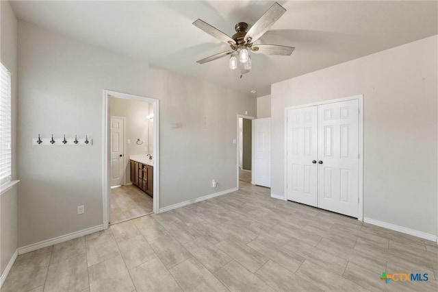 unfurnished bedroom featuring ceiling fan, baseboards, a closet, and ensuite bathroom