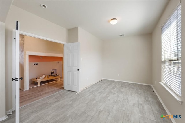 unfurnished bedroom with light wood-style flooring, visible vents, and baseboards