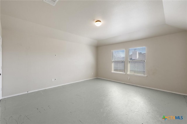 spare room featuring vaulted ceiling, concrete floors, visible vents, and baseboards