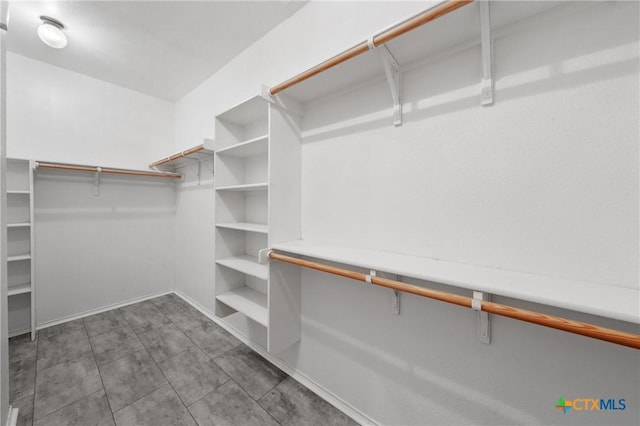 walk in closet featuring dark tile patterned floors