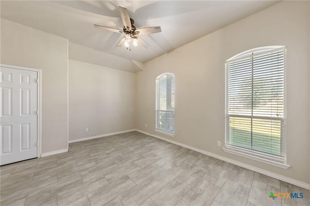 spare room with baseboards and a ceiling fan