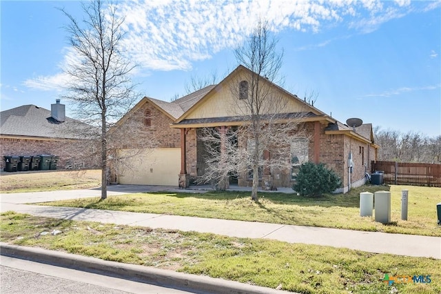 view of front facade with a garage, brick siding, fence, driveway, and a front lawn