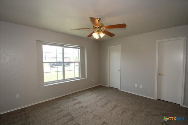 carpeted empty room with baseboards and ceiling fan