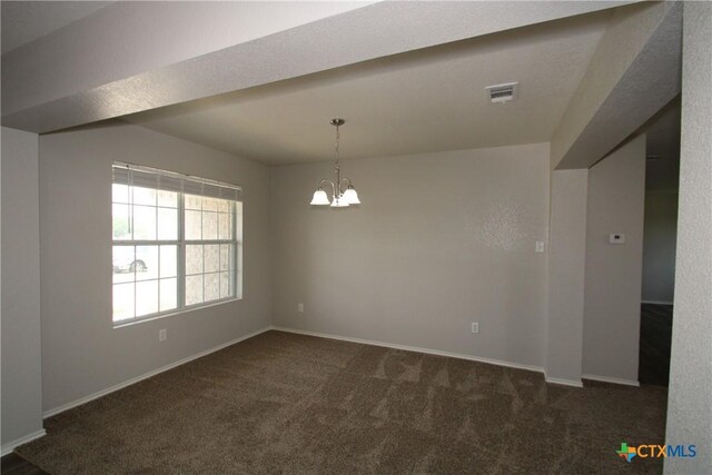 carpeted spare room featuring baseboards, visible vents, and an inviting chandelier
