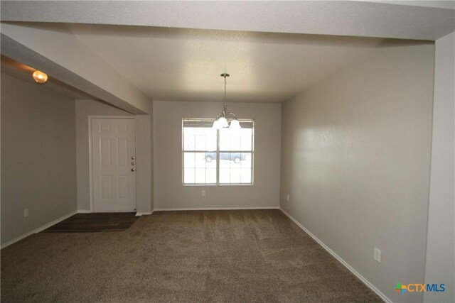 spare room with an inviting chandelier, baseboards, and dark colored carpet