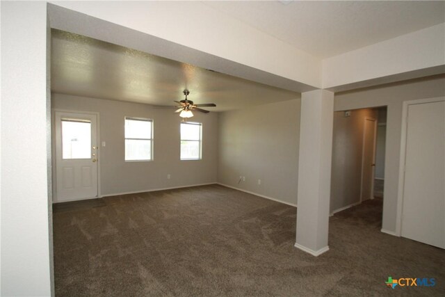 unfurnished living room with carpet flooring, ceiling fan, and baseboards