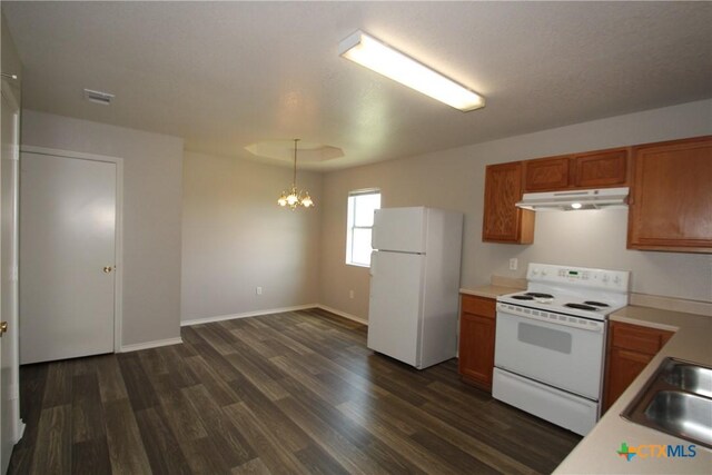 kitchen with brown cabinets, white appliances, a chandelier, under cabinet range hood, and dark wood-style floors